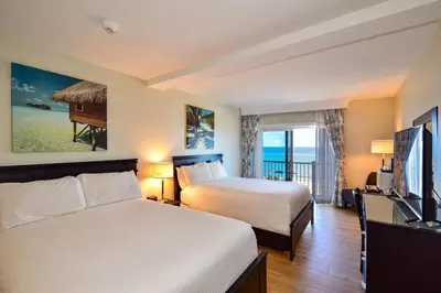 a hotel room with two beds and a television at Sun Tower Hotel & Suites on the Beach in Fort Lauderdale