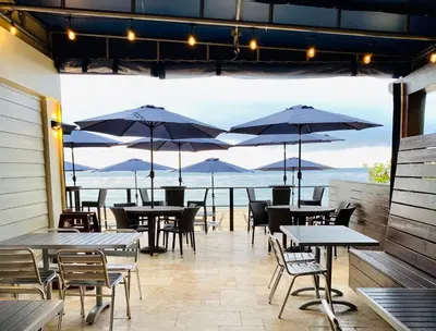 a patio with tables and chairs and umbrellas at Sun Tower Hotel & Suites on the Beach in Fort Lauderdale