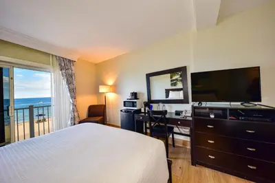 a hotel room with a bed and a desk and a television at Sun Tower Hotel & Suites on the Beach in Fort Lauderdale