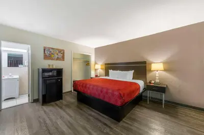 a hotel room with a bed and a bathroom at Fort Lauderdale Gardens Inn & Suites Ft Lauderdale International Airport in Hollywood