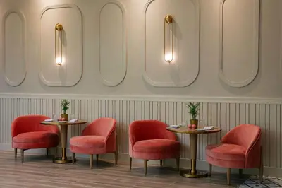 a restaurant with red chairs and tables and mirrors at Sonesta Miami Airport in Miami