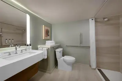 a white bathroom with a sink and a toilet at Sonesta Miami Airport in Miami