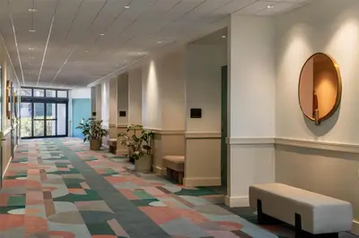 a lobby with a waiting area with a mirror and benches at Sonesta Miami Airport in Miami