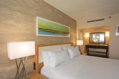 a bedroom with a white bed and a piano at Holiday Inn Miami Beach-Oceanfront by IHG in Miami Beach