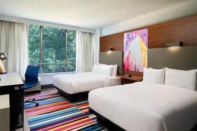 a hotel room with two beds and a desk at Aloft Miami Dadeland in Kendall