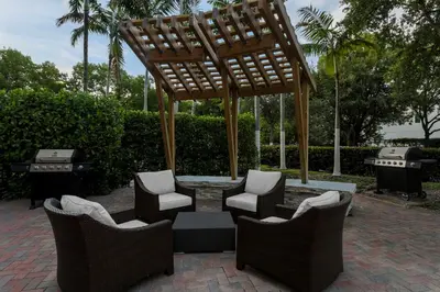 a patio with chairs and a table with a wooden structure at Staybridge Suites Miami Doral Area by IHG in Miami