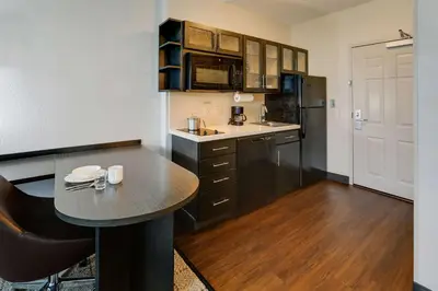 a small kitchen with a table and a refrigerator at Sonesta Simply Suites Miami Airport Doral in Miami