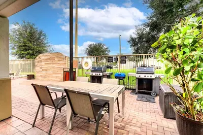 a patio with a wooden table and chairs and a grill at Sonesta Simply Suites Miami Airport Doral in Miami