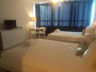 a hotel room with two beds and a television at L&D Vacations Rentals in Miami Beach