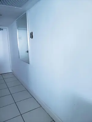 an empty room with a white wall and a mirror at L&D Vacations Rentals in Miami Beach