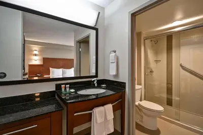 a bathroom with a sink and a toilet and a mirror at Hyatt Place Miami Airport-West/Doral in Miami