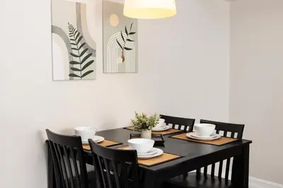 a dining room with a black table and black chairs at Ocean Reef Suites in Miami Beach