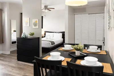 a living room with a dining room table and a bed at Ocean Reef Suites in Miami Beach