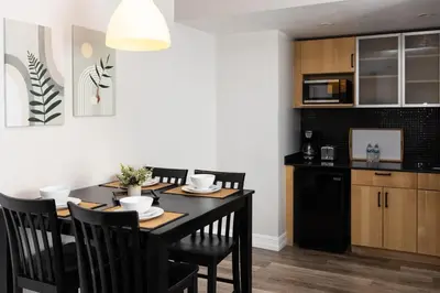a kitchen and dining room with a black table and chairs at Ocean Reef Suites in Miami Beach