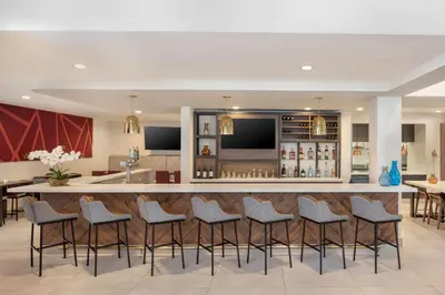 a bar in a hotel lobby with stools at Hilton Garden Inn Miami Airport West in Miami