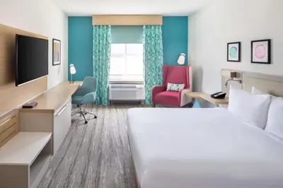 a hotel room with a bed and a desk and a chair at Hilton Garden Inn Miami Airport West in Miami