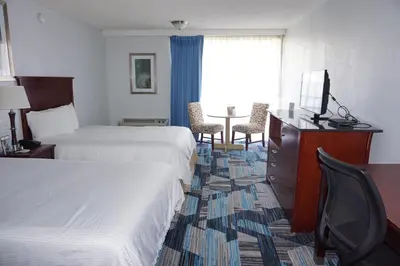 a hotel room with two beds and a table at The Hollywood Gateway Inn in Hollywood