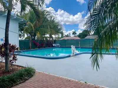 a swimming pool in a resort with a palm tree at The Hollywood Gateway Inn in Hollywood