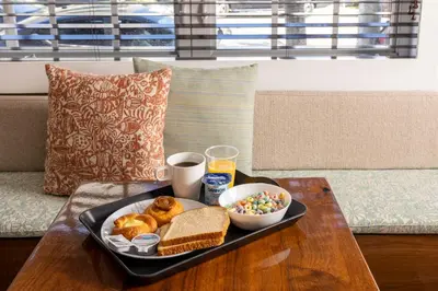 a tray of breakfast food on a table on a couch at Riviere South Beach Hotel in Miami Beach