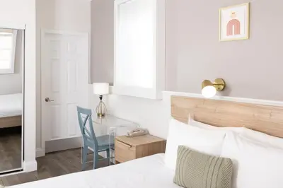 a bedroom with a bed and a desk with a chair at Riviere South Beach Hotel in Miami Beach