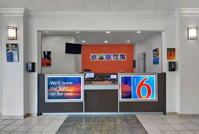 a lobby with a reception desk and a television at Motel 6-Cutler Bay, FL in Cutler Bay