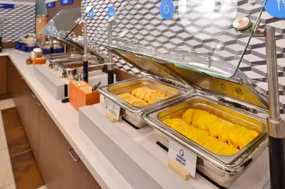 a buffet line with trays of food on display at Holiday Inn Express Ft Lauderdale Cruise-Airport by IHG in Fort Lauderdale