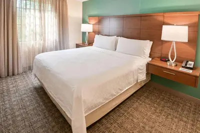 a hotel room with a large bed and a lamp at Sonesta ES Suites Fort Lauderdale Plantation in Plantation