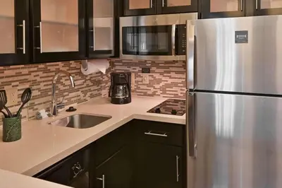 a kitchen with a stainless steel refrigerator and a sink at Sonesta ES Suites Fort Lauderdale Plantation in Plantation