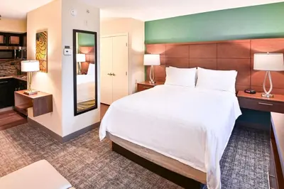 a hotel room with a large bed and a mirror at Sonesta ES Suites Fort Lauderdale Plantation in Plantation