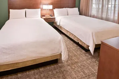 a hotel room with two beds and a table at Sonesta ES Suites Fort Lauderdale Plantation in Plantation