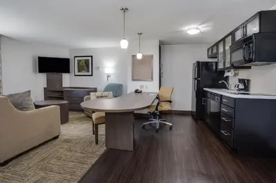 a living room with a kitchen and a table in a room at Candlewood Suites Fort Lauderdale Airport-Cruise by IHG in Fort Lauderdale
