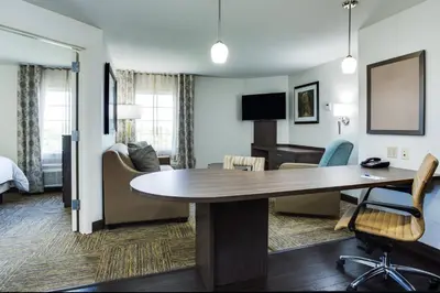 a hotel room with a table and a living room at Candlewood Suites Fort Lauderdale Airport-Cruise by IHG in Fort Lauderdale