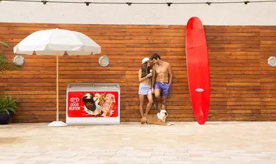 two men and a dog standing next to a wall with a surfboard at Sole Miami, A Noble House Resort in Miami Beach
