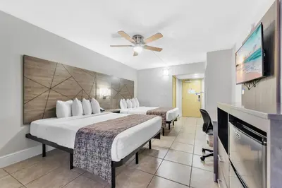 a hotel room with two beds and a flat screen tv at Rodeway Inn & Suites Fort Lauderdale Airport & Cruise Port in Fort Lauderdale