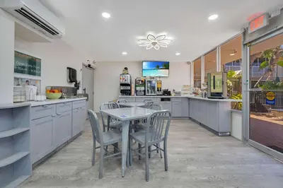 a kitchen with a table and chairs in it at Quality Inn & Suites Airport-Cruise Port Hollywood in Hollywood