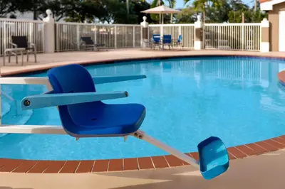 a blue chair sitting in front of a swimming pool at Holiday Inn Express & Suites Pembroke Pines-Sheridan St by IHG in Pembroke Pines