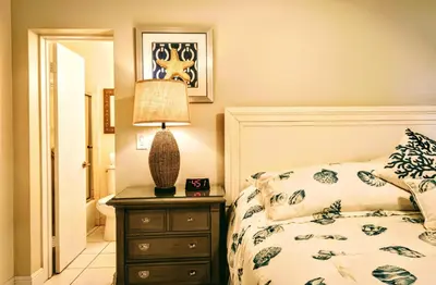 a bedroom with a bed and a lamp on a dresser at Villa Venezia in Fort Lauderdale