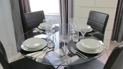 a glass table with chairs and plates and wine glasses at Ocean Dream in Miami Beach