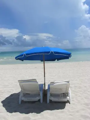 two chairs and an umbrella on a beach at Ocean Dream in Miami Beach