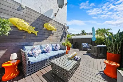 a patio with a couch and tables and plants at Hollywood Beach Suites and Hotel in Hollywood