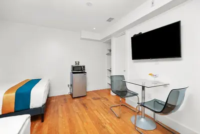 a bedroom with a bed and a table and chairs at Hollywood Beach Suites and Hotel in Hollywood