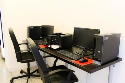a desk with four computer monitors and a keyboard at Collins Hotel in Miami Beach
