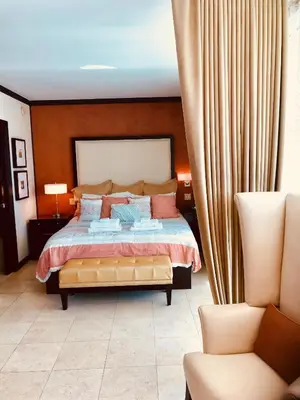 a bedroom with a large bed and a chair at Apartment at De Soleil Hotel on Ocean Drive in Miami Beach