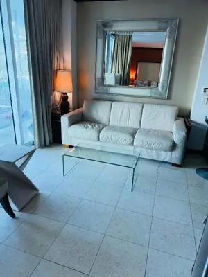 a living room with a white couch and a mirror at Apartment at De Soleil Hotel on Ocean Drive in Miami Beach