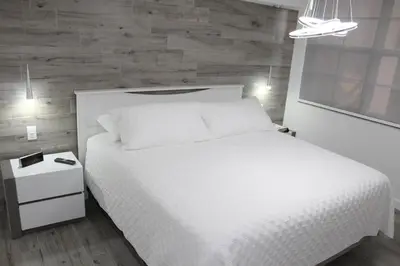 a bedroom with a white bed and a wooden wall at Yacht Club at Aventura Luxurious 1 Bed 1 Bath in Aventura