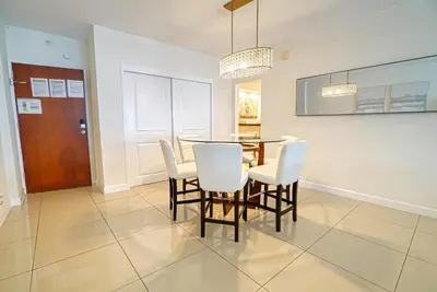 a dining room with a table and white chairs at Hollywood apartment by the sea in Hollywood