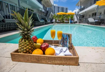 a tray of fruit and drinks next to a pool at Waterside Hotel and Suites in Miami Beach