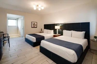 a hotel room with two beds and a table at Waterside Hotel and Suites in Miami Beach