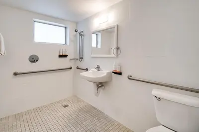 a white bathroom with a toilet and a sink at Waterside Hotel and Suites in Miami Beach