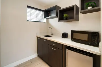a small kitchen with a microwave and a sink at Waterside Hotel and Suites in Miami Beach